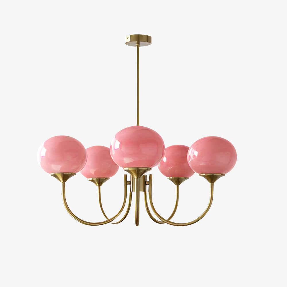  De LichtWolk Marshmallow Luchter, een elegante hanglamp met vijf zachte, amberkleurige glazen bollen en een luxe gouden frame, hangt boven een tafel gedrapeerd met een groene doek. Op de tafel staan een mok en een decoratieve rieten bloemenmand, wat een warme en stijlvolle sfeer toevoegt aan het interieur. Perfect voor een verfijnde woonkamer of eetkamer.