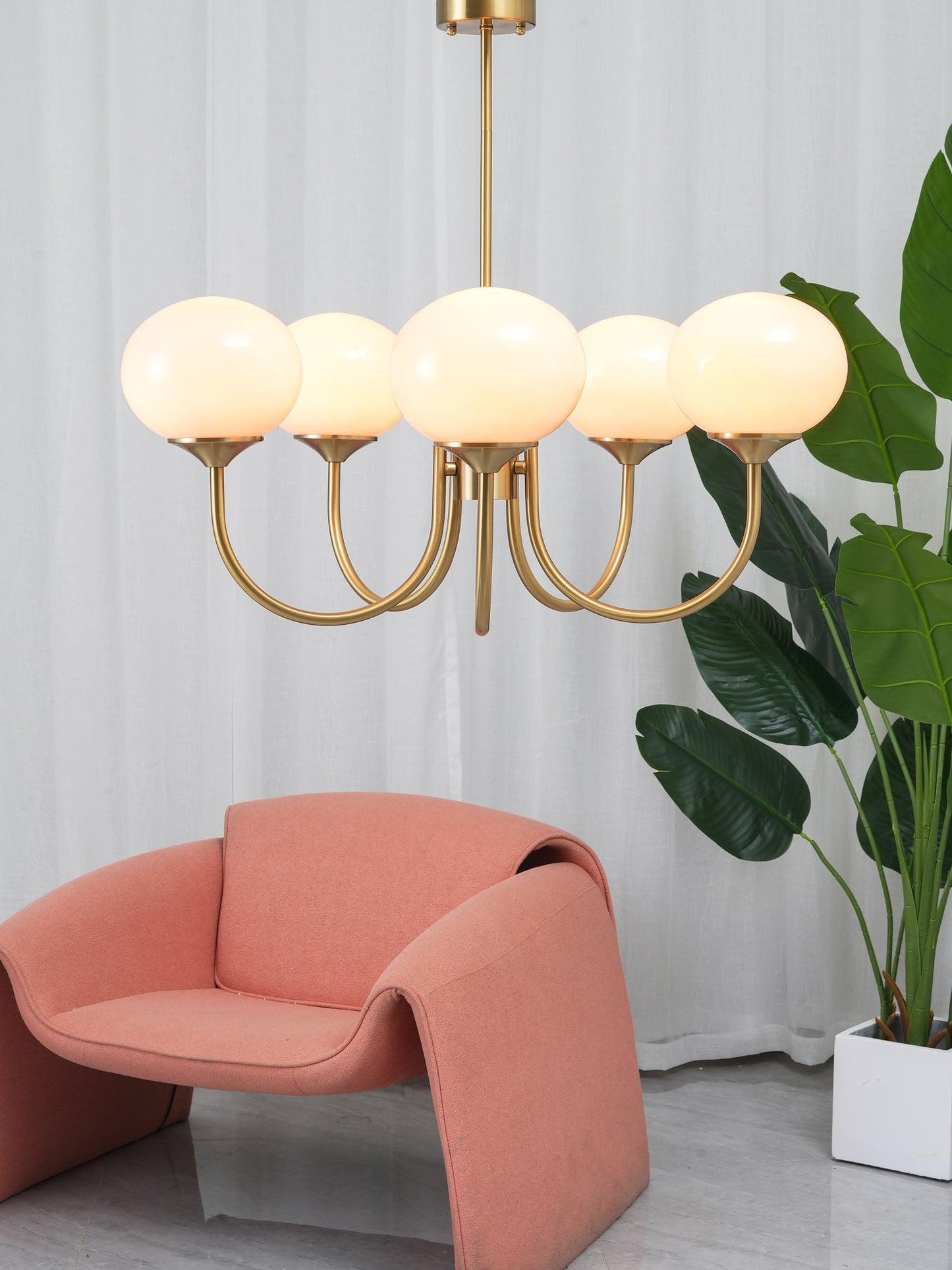 Stijlvolle LichtWolk Marshmallow Luchter met vijf zachte, warm verlichte glazen bollen en een elegant gouden frame. Deze luxe hanglamp voegt een verfijnde, warme gloed toe aan elke ruimte, ideaal voor een gezellige en stijlvolle sfeer in de eetkamer of woonkamer.